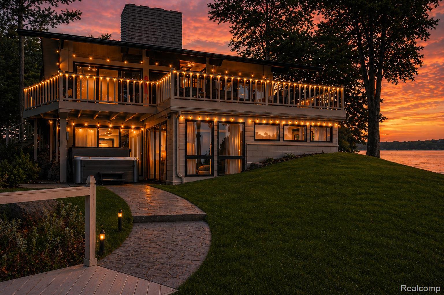 2380 Islanders Way Gladwin, MI 48624 - Photo 3 of 48 Back of house at dusk featuring a hot tub, a chimney, a balcony, and a lawn
