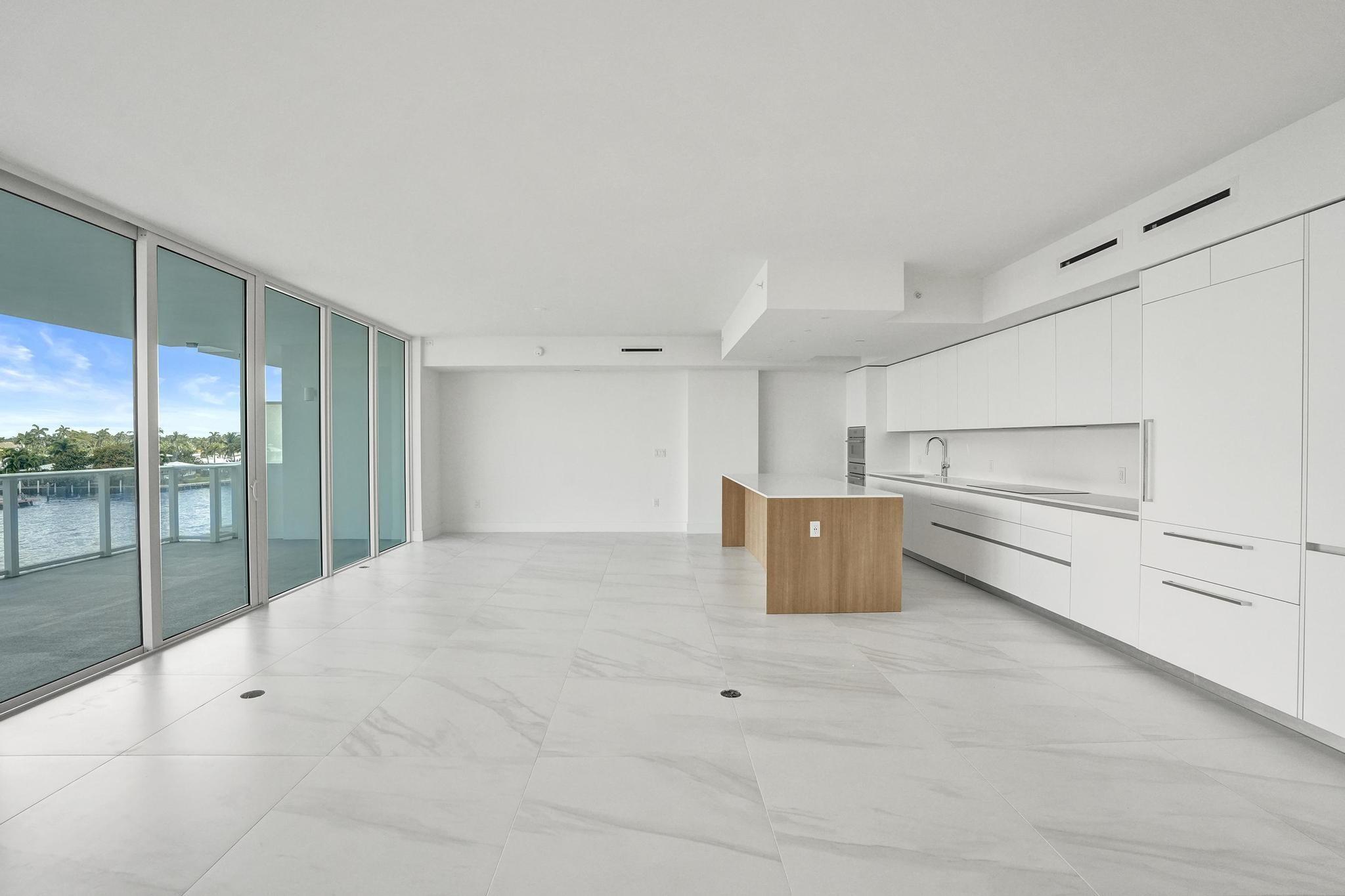 407 North Riverside Drive, Unit 303 Pompano Beach, FL 33062 - Photo 5 of 74 a view of a kitchen with a refrigerator an oven and white cabinets