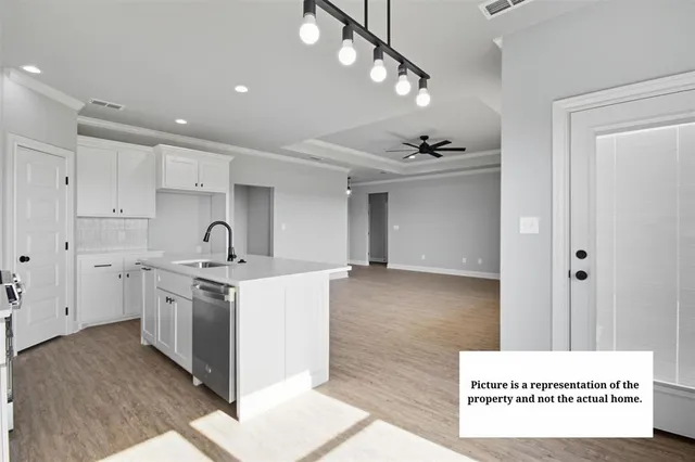 a kitchen with stainless steel appliances kitchen island a sink dishwasher a stove and a refrigerator with wooden floor