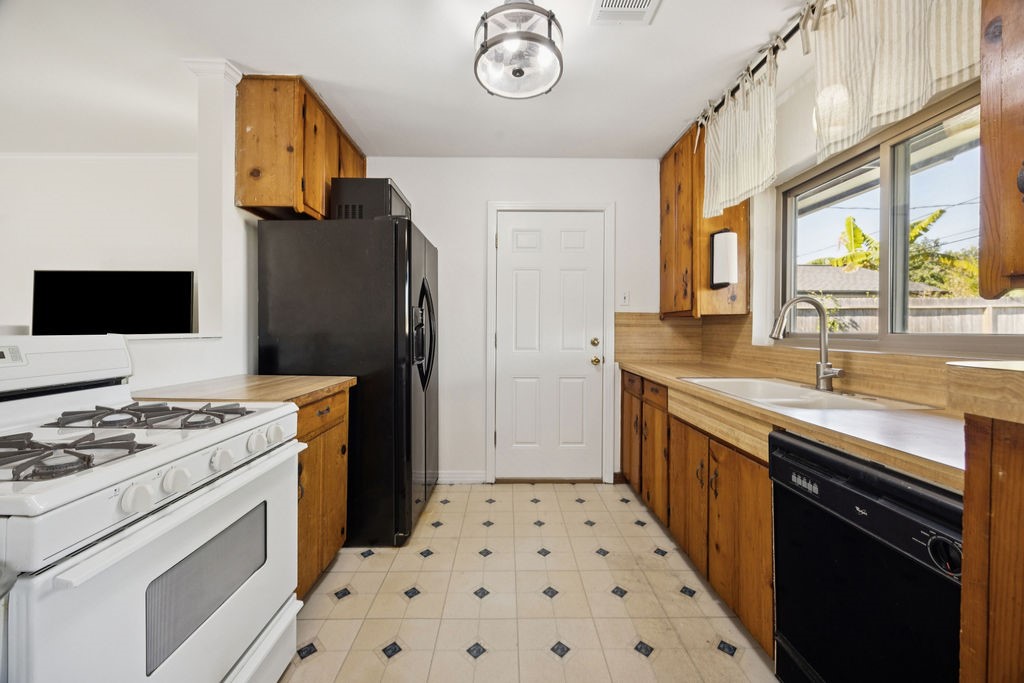 1122 West 31st Street Houston, TX 77018 - Photo 5 of 12 a kitchen with a stove and a refrigerator