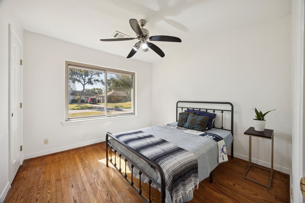1122 West 31st Street Houston, TX 77018 - Photo 7 of 12 a bedroom with a bed and wooden floor