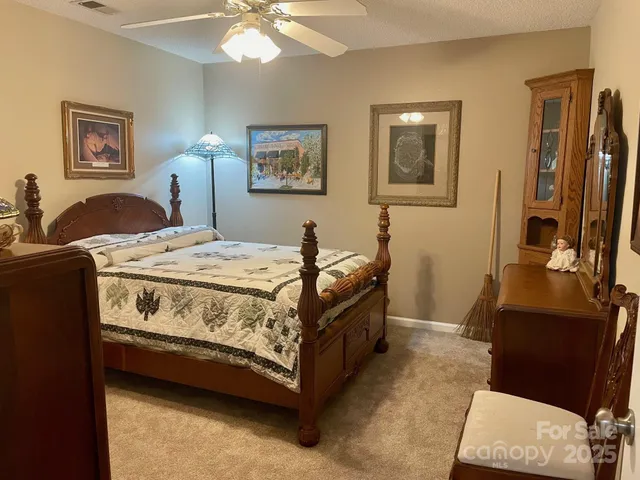 a bedroom with a bed and a mirror on the dresser