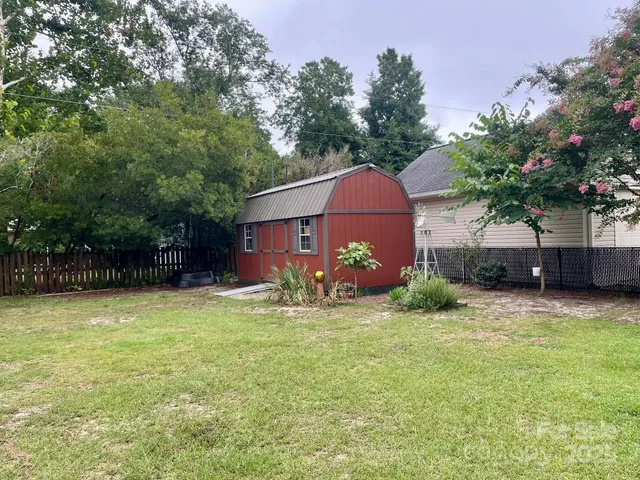 a view of a house with a yard and a tree