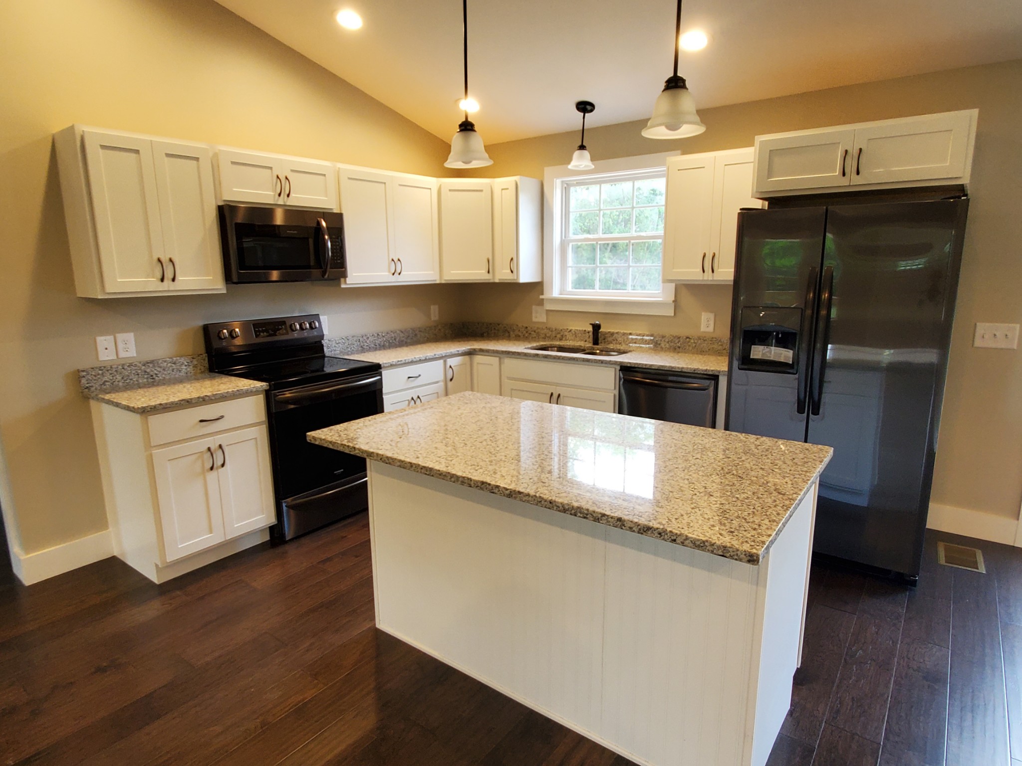 155 Bellwood Road Lebanon, TN 37087 - Photo 8 of 16 a kitchen with stainless steel appliances granite countertop a sink a stove a microwave a refrigerator a sink and dishwasher with wooden floor
