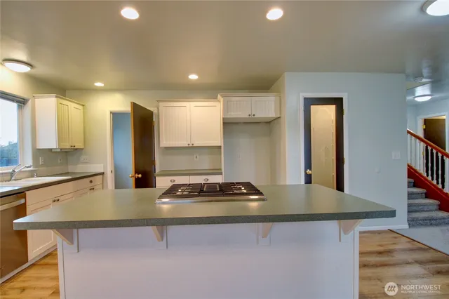 a kitchen with kitchen island a sink stove and refrigerator