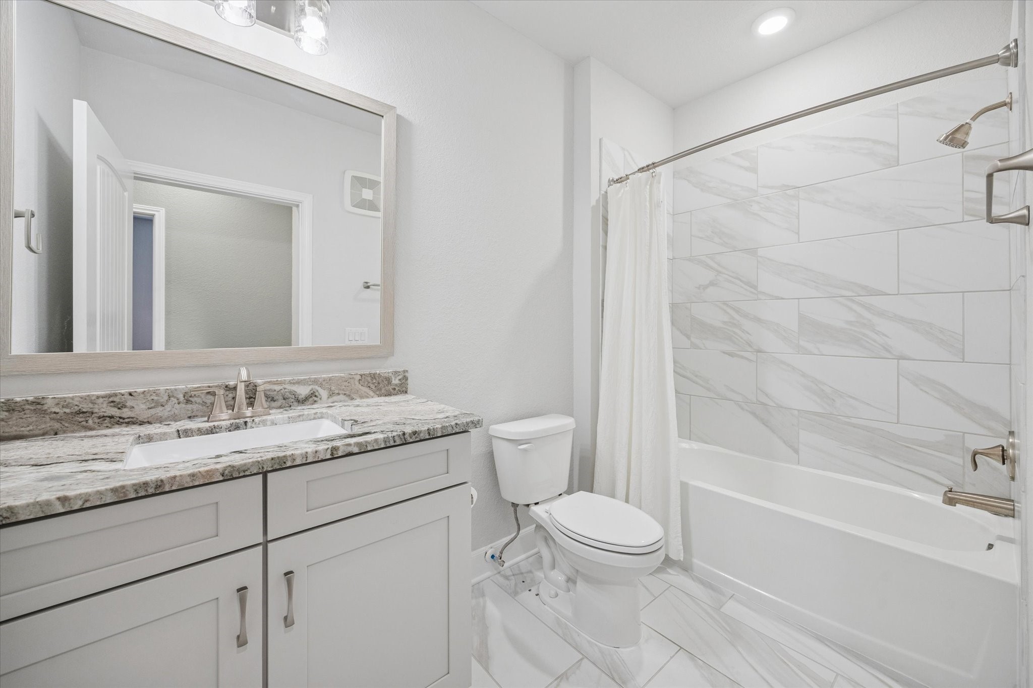 6804 Westview Drive, Unit 2205 Houston, TX 77055 - Photo 11 of 23 The secondary bathroom, serving the guest bedroom, features a modern vanity with stylish countertops and a clean, white cabinetry design.