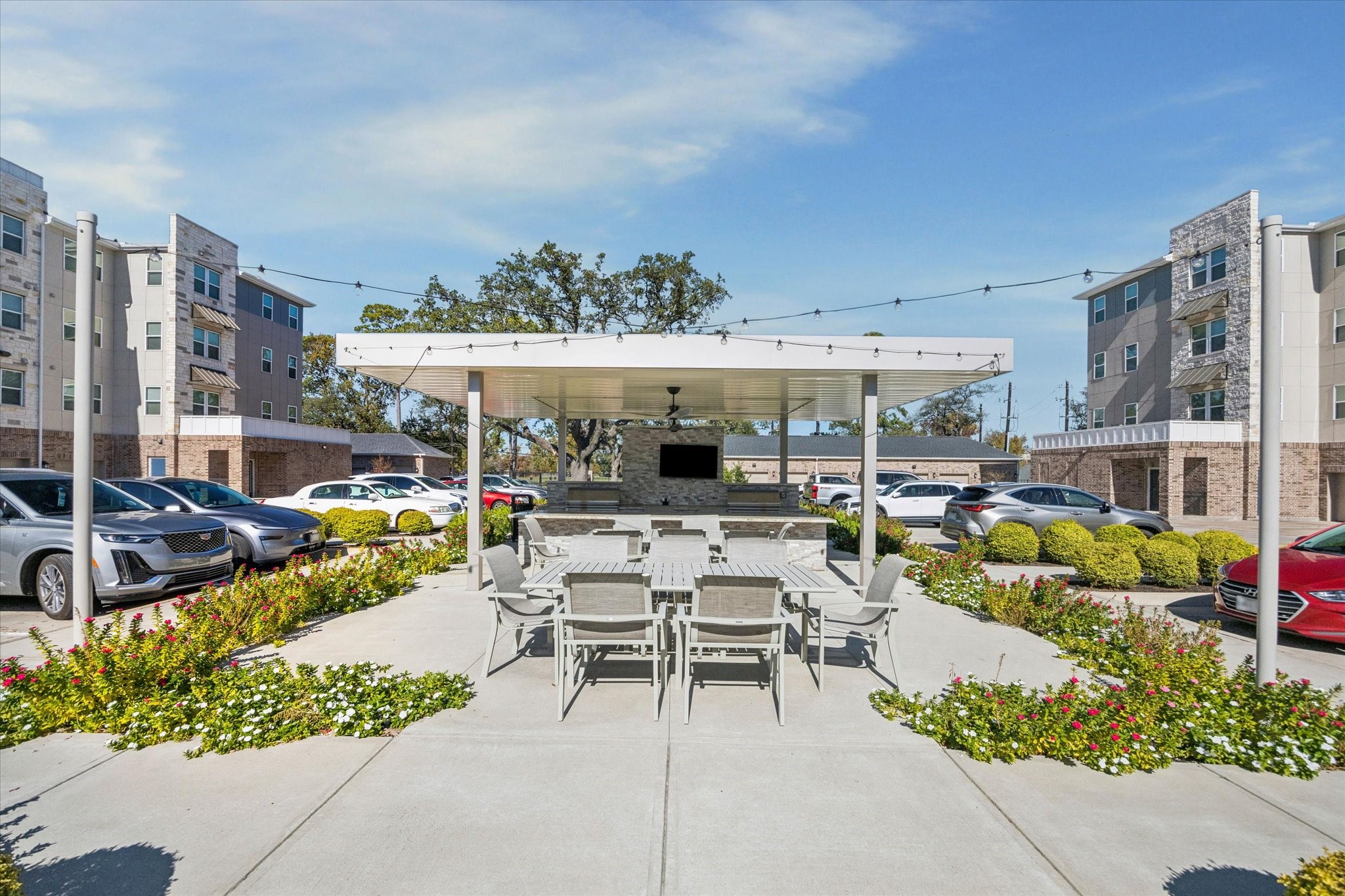 6804 Westview Drive, Unit 2205 Houston, TX 77055 - Photo 16 of 23 Residents enjoy a premium outdoor kitchen amenity that features a large, covered pavilion perfect for alfresco dining and entertaining. This stylish community space is equipped with a built-in grill station, ample stone-countertop prep space, and a comfortable shaded seating area centered around an outdoor television.