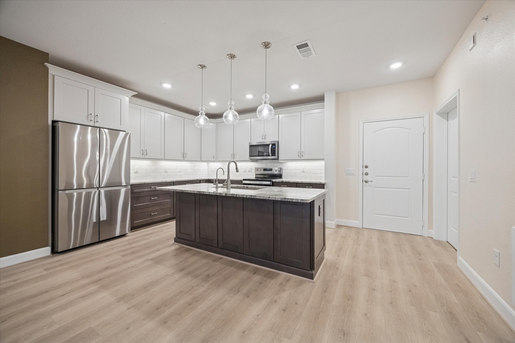 Kitchen [12'x7']- This modern kitchen features stylish two-tone cabinetry with soft-close drawers and premium Samsung stainless steel appliances.