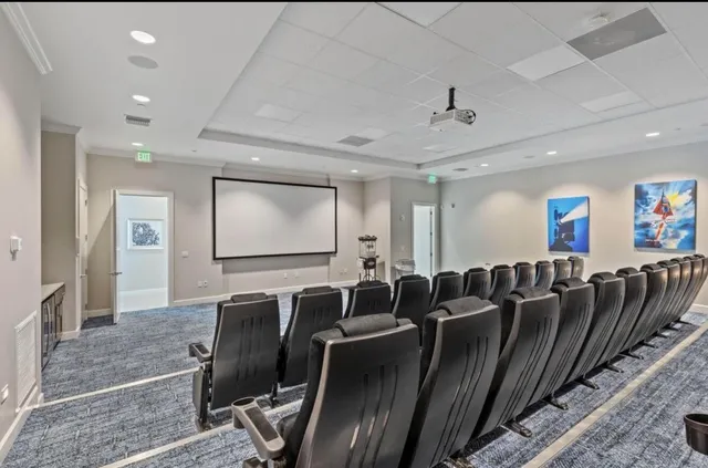 a media room with lots of chairs and a projector screen