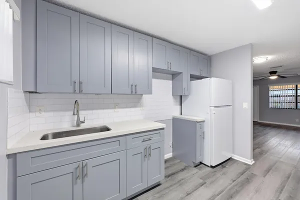 a kitchen with a sink cabinets stainless steel appliances and wooden floor