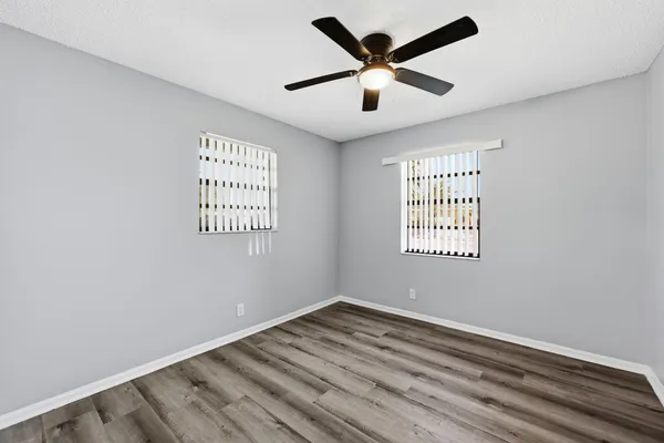 an empty room with a window and a ceiling fan