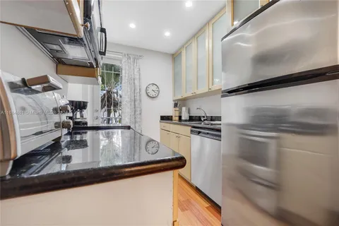 a kitchen with kitchen island a counter top space a sink stainless steel appliances and cabinets