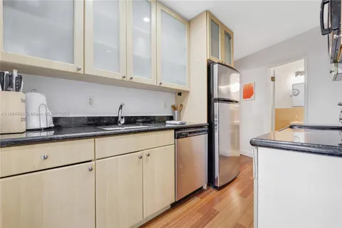 a kitchen with stainless steel appliances granite countertop a sink and a refrigerator