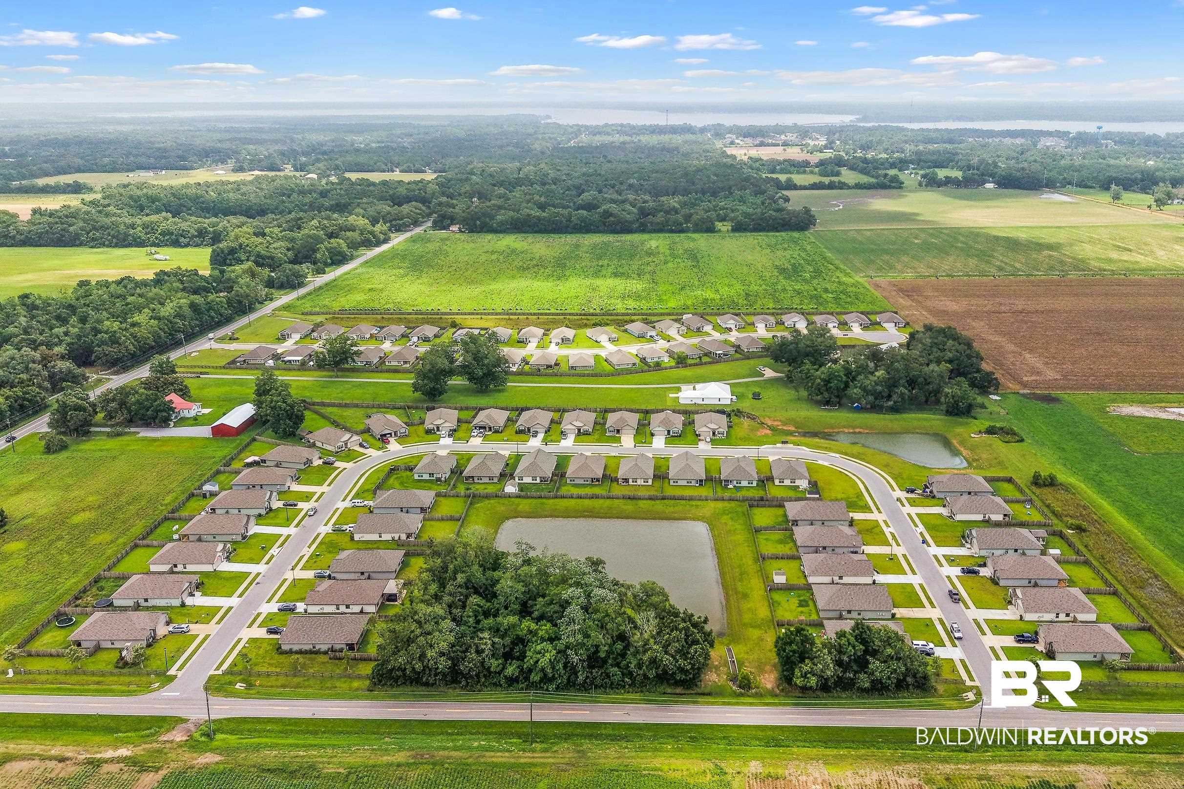 32030 Terranova Loop Lillian, AL 36549 - Photo 27 of 30 Aerial perspective showcasing a residential community with multiple homes, paved roadways, and two central water features
