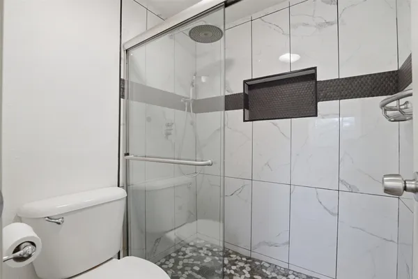 a bathroom with a toilet and a shower
