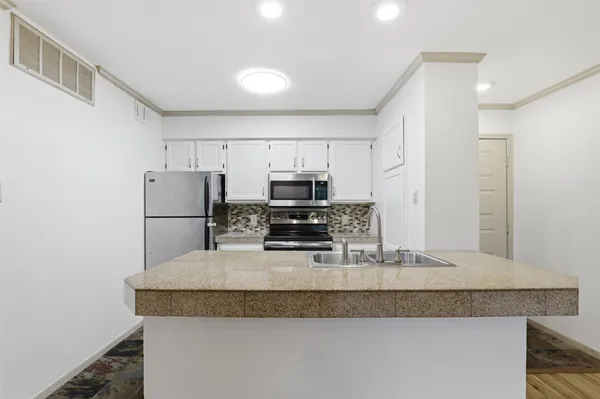 a kitchen with granite countertop a refrigerator and a sink