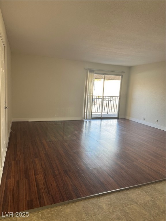 5188 River Glen Drive, Unit 458 Las Vegas, NV 89103 - Photo 2 of 13 Empty room with dark wood-style floors and baseboards