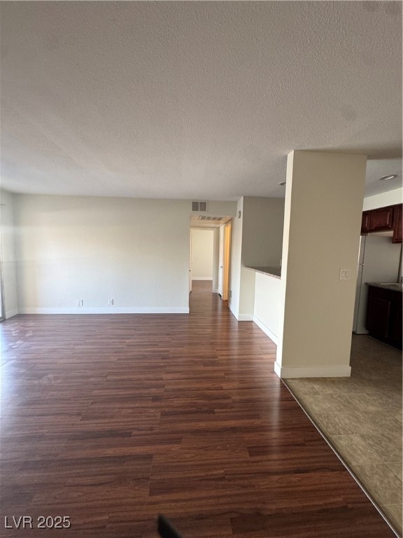5188 River Glen Drive, Unit 458 Las Vegas, NV 89103 - Photo 4 of 13 Unfurnished living room with dark wood-type flooring and a textured ceiling