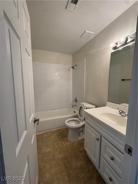 5188 River Glen Drive, Unit 458 Las Vegas, NV 89103 - Photo 5 of 13 Full bathroom featuring a textured wall, shower / bathtub combination, vanity, a textured ceiling, and dark tile patterned floors