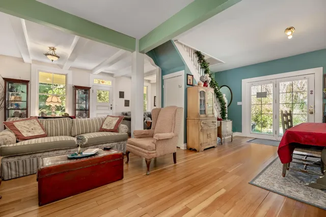 a bedroom with a bed couch and a large window with wooden floor