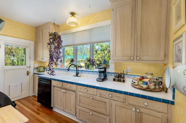 a kitchen that has a lot of cabinets and a wooden floor