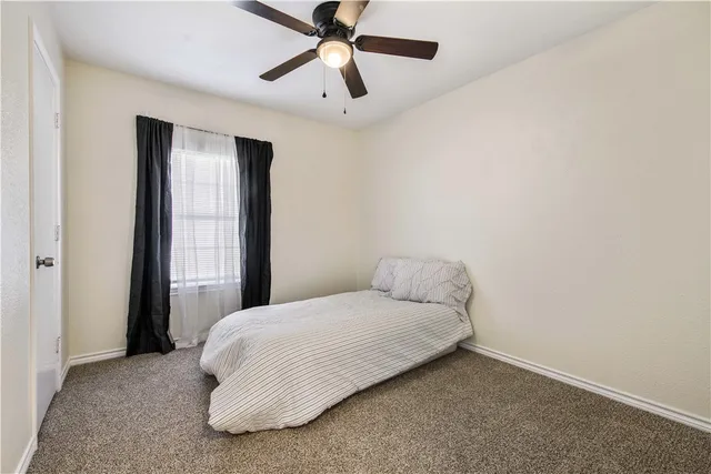 a bedroom with a bed and a ceiling fan