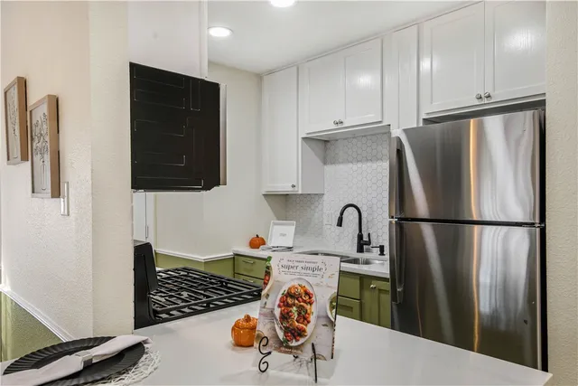 a kitchen with stainless steel appliances granite countertop a refrigerator and a stove top oven