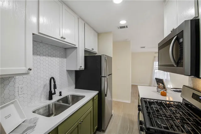 a kitchen with stainless steel appliances a sink stove and refrigerator