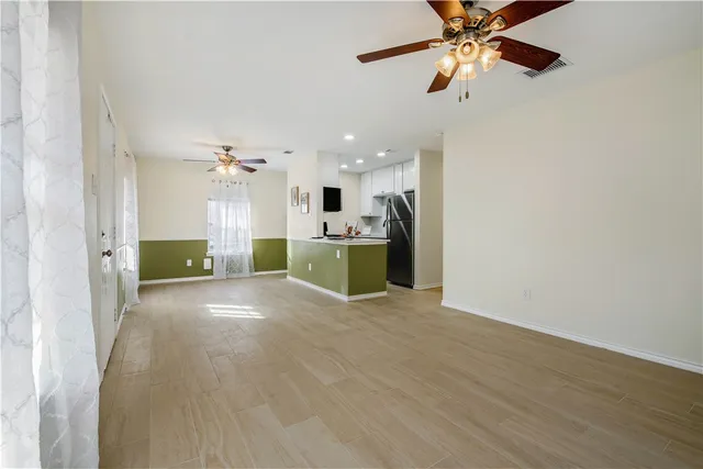 a view of a kitchen with a sink and cabinet with a flat screen tv