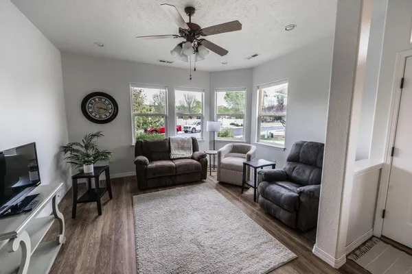 a living room with furniture a flat screen tv and a large window