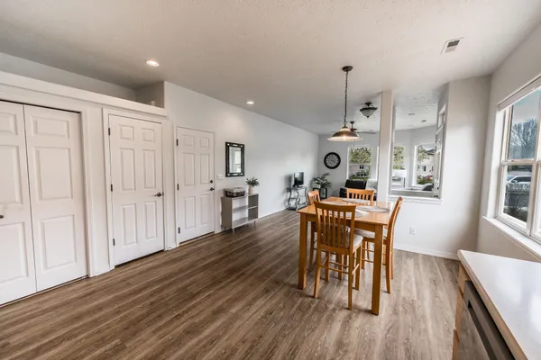 a dining room with wooden floor a chandelier a wooden table and chairs