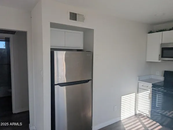 a walk in closet with wooden floor