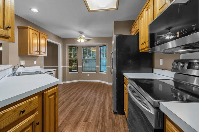 a kitchen with a sink and wooden floor