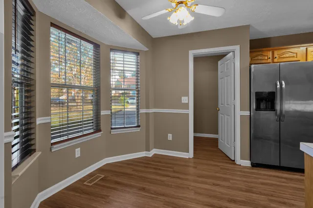 a view of an empty room with a window and wooden floor