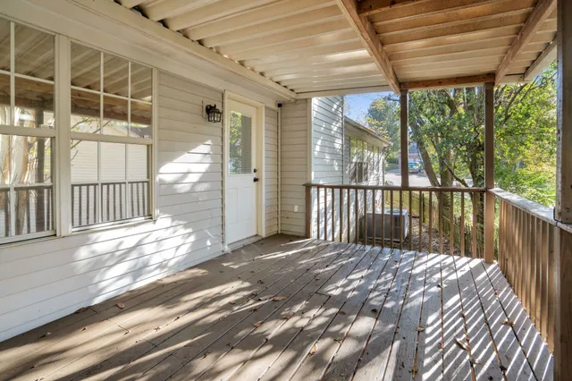 a view of backyard with large trees and wooden fence