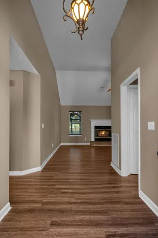 a view of empty room with wooden floor and window