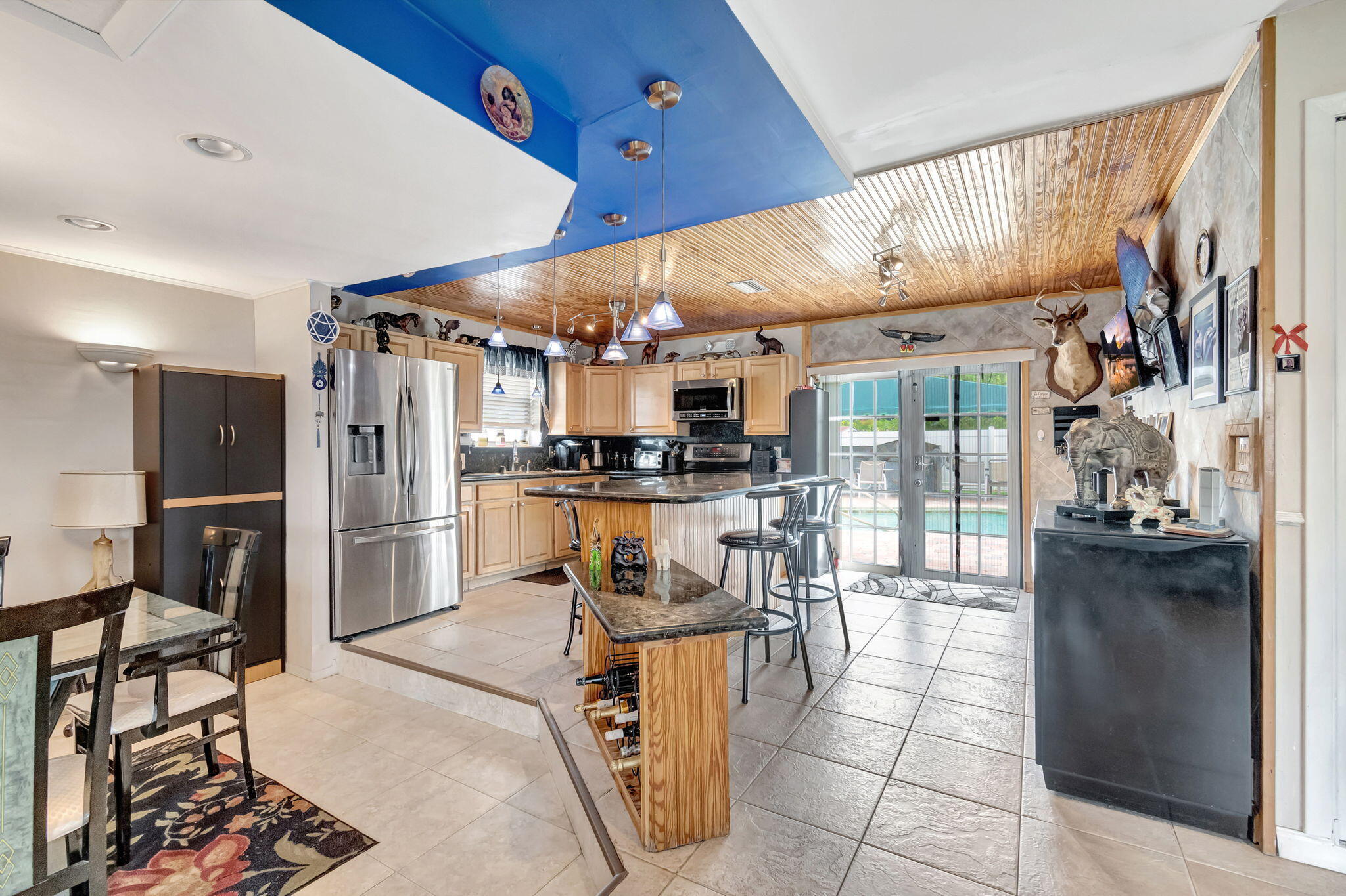 4557 Avalon Street Boca Raton, FL 33428 - Photo 13 of 47 a kitchen with stainless steel appliances kitchen island granite countertop a refrigerator and a stove