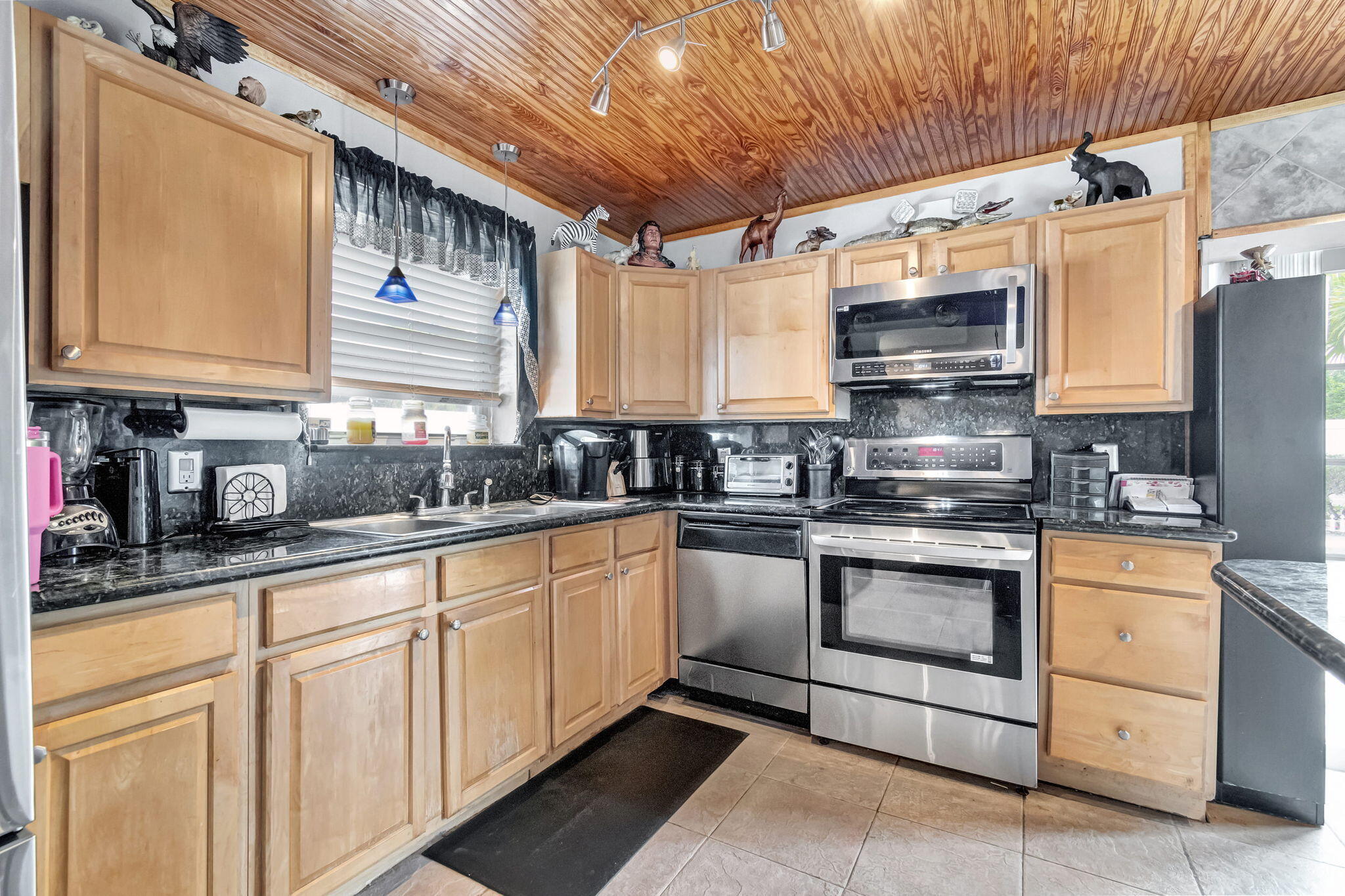 4557 Avalon Street Boca Raton, FL 33428 - Photo 14 of 47 a kitchen with stainless steel appliances granite countertop a sink a stove and cabinets