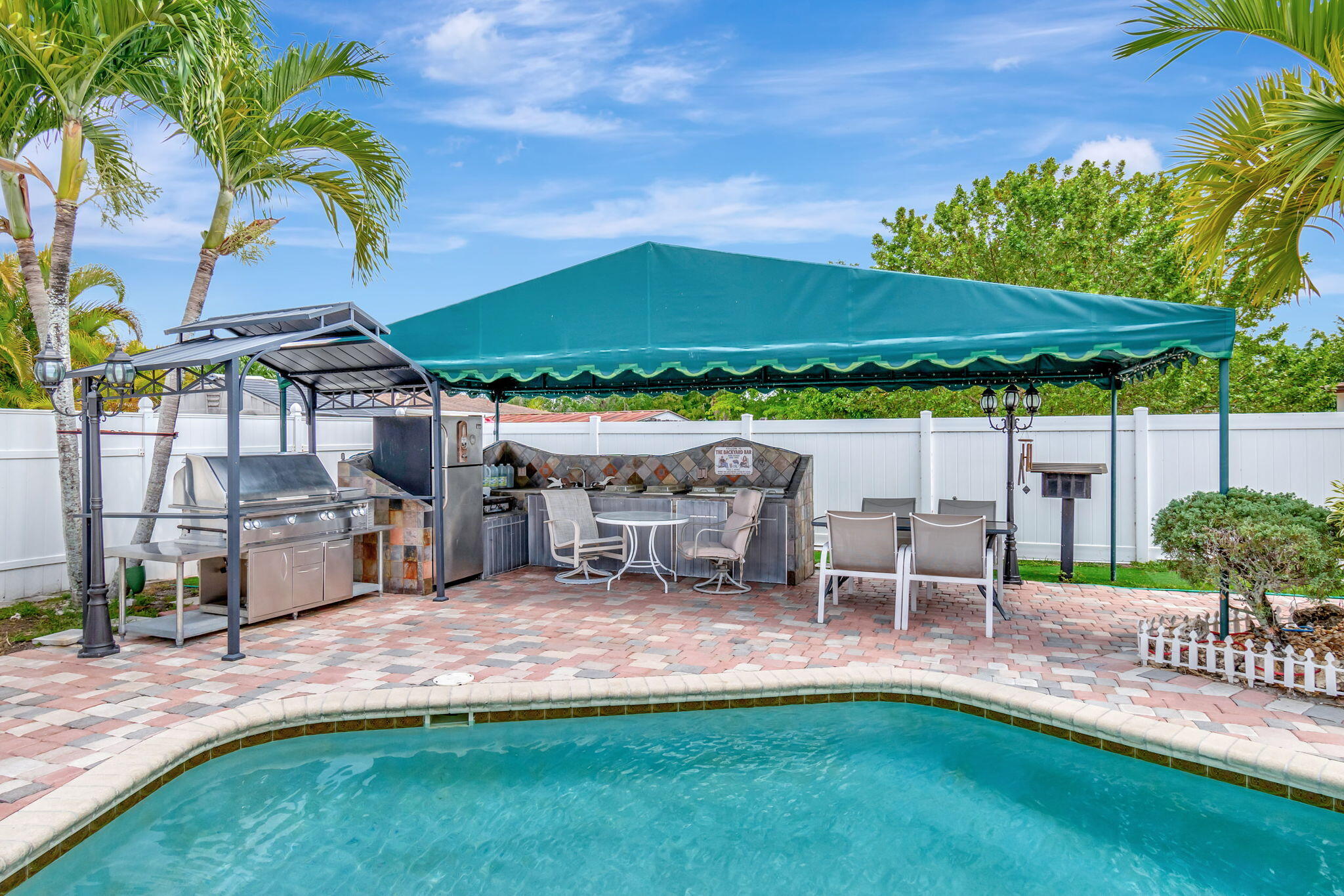 4557 Avalon Street Boca Raton, FL 33428 - Photo 42 of 47 a view of a patio with table and chairs under an umbrella