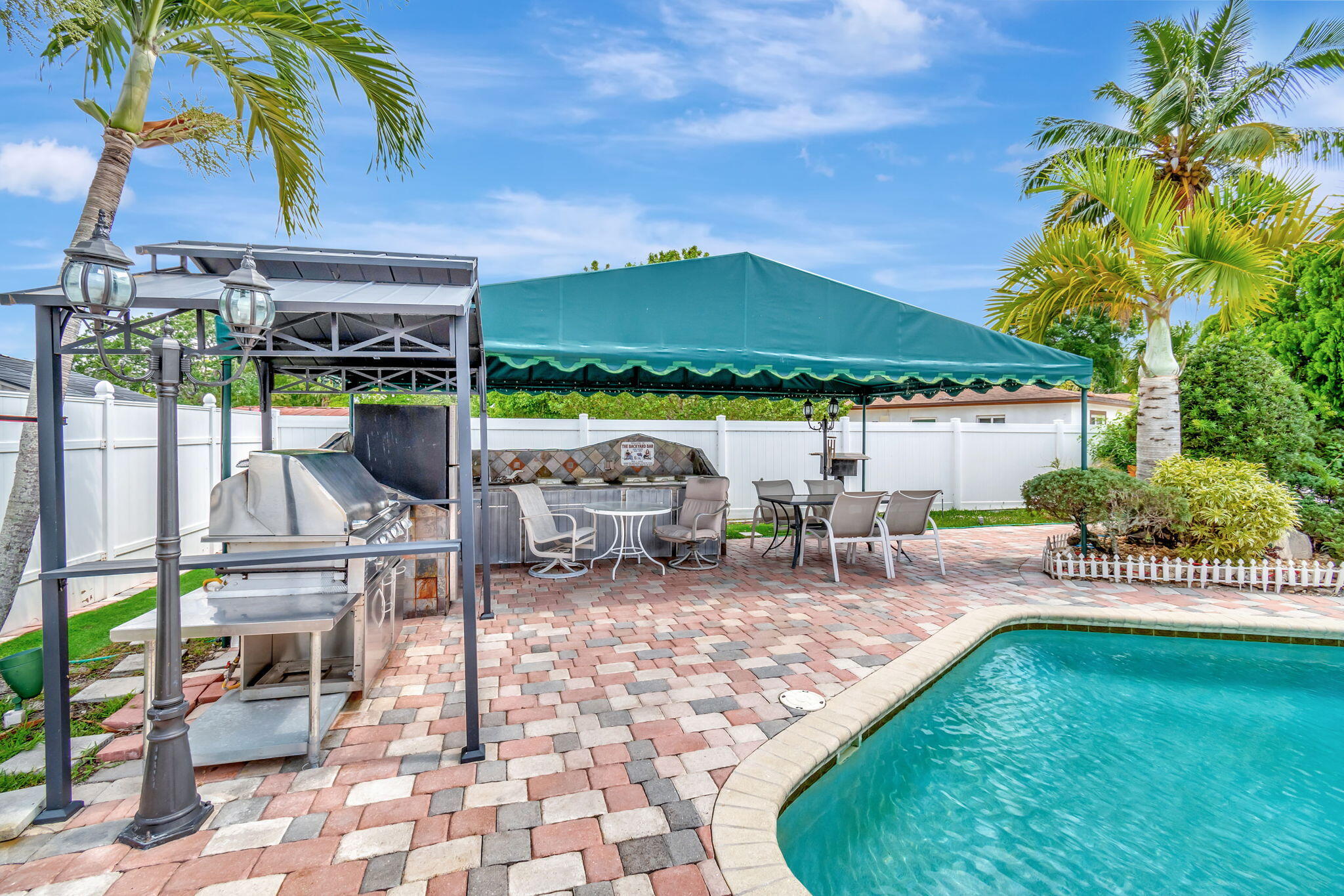 4557 Avalon Street Boca Raton, FL 33428 - Photo 43 of 47 a view of a patio with a table and chairs under an umbrella
