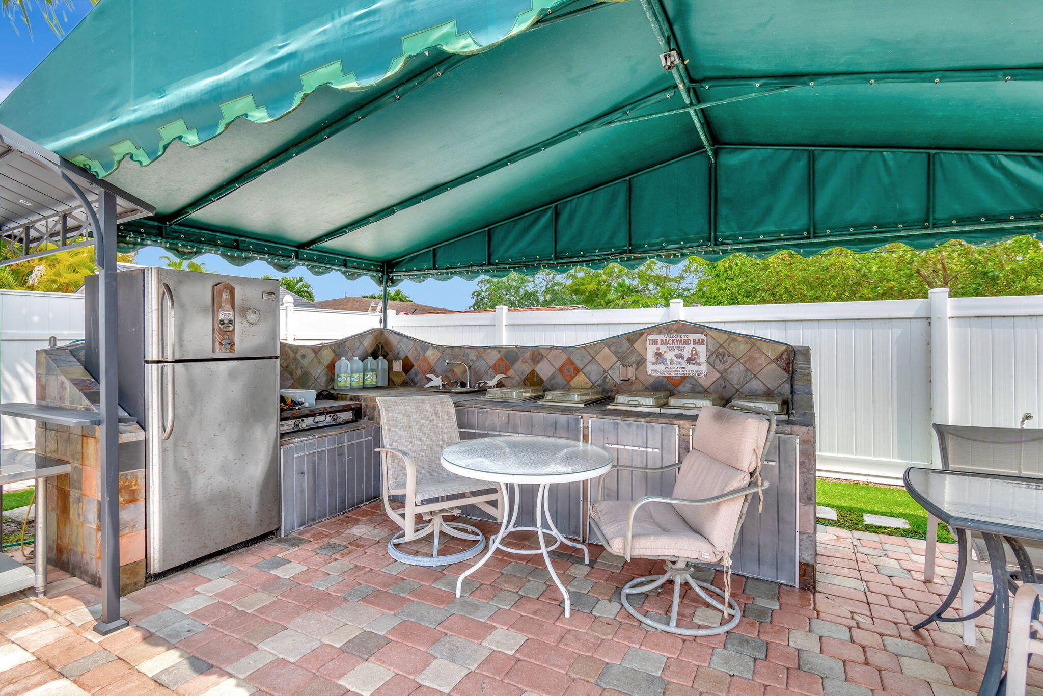 4557 Avalon Street Boca Raton, FL 33428 - Photo 44 of 47 a view of an outdoor dining space with a table and chairs