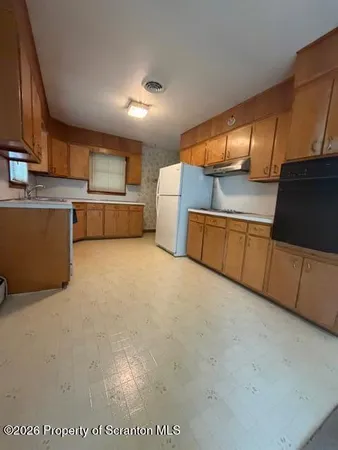 a kitchen with stainless steel appliances a refrigerator and wooden cabinets