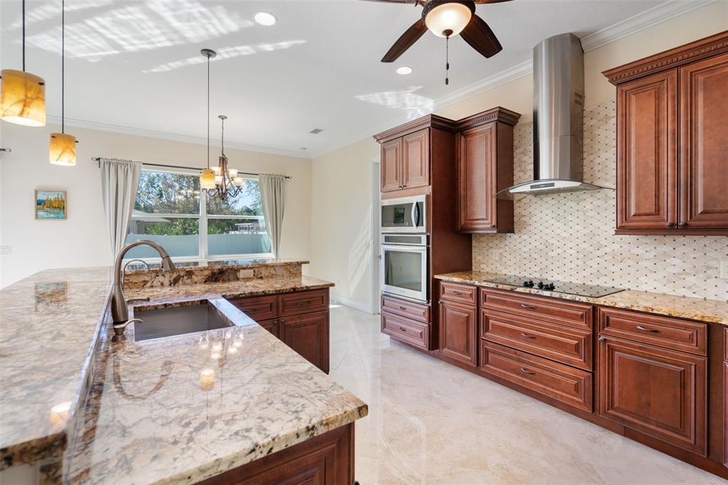 1900 Colleen Street Sarasota, FL 34231 - Photo 12 of 49 a kitchen with stainless steel appliances granite countertop a stove a refrigerator and a sink with wooden floor