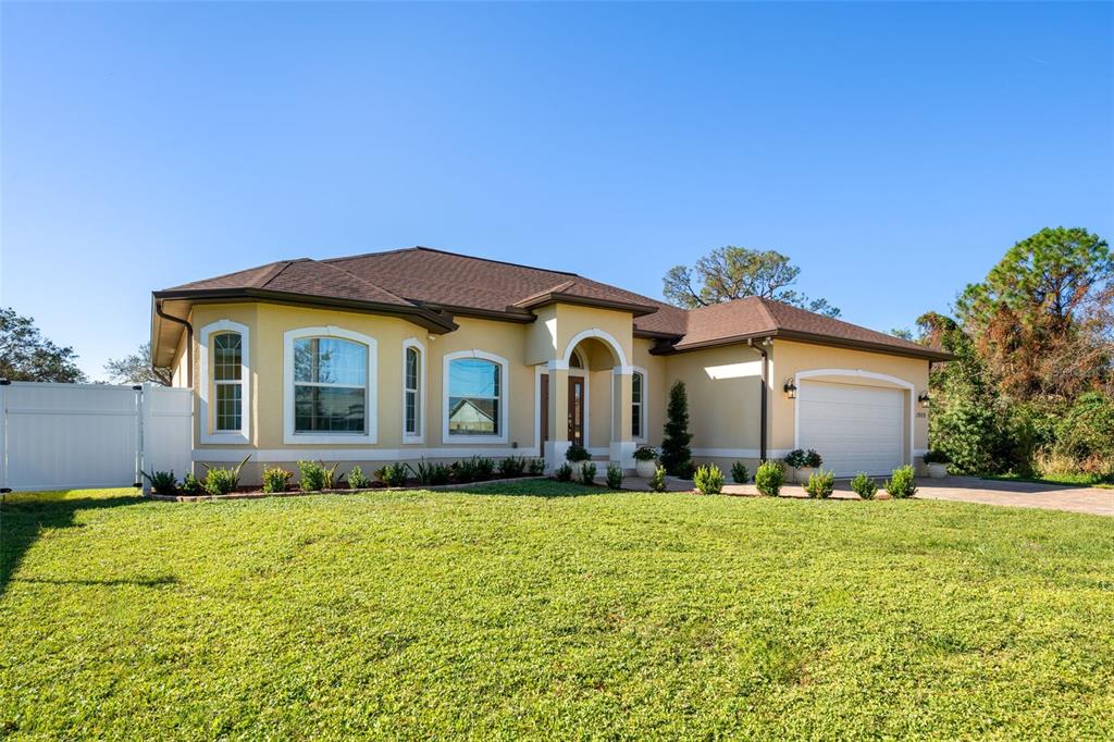 1900 Colleen Street Sarasota, FL 34231 - Photo 2 of 49 a front view of house with yard and trees in the background