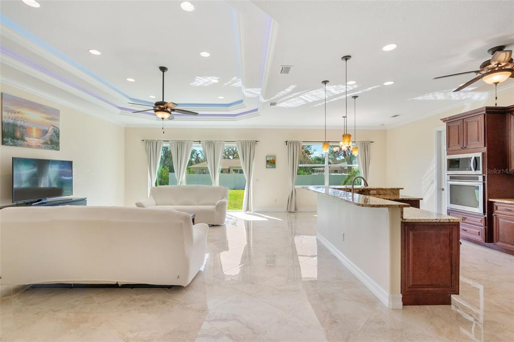 1900 Colleen Street Sarasota, FL 34231 - Photo 8 of 49 a large living room with stainless steel appliances granite countertop furniture a fireplace a flat screen tv and kitchen view