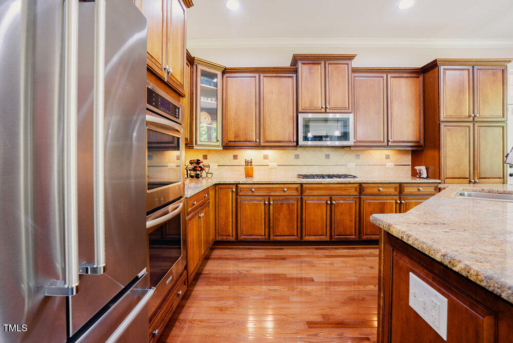 3911 Morvan Way Raleigh, NC 27612 - Photo 20 of 68 a kitchen with stainless steel appliances granite countertop a sink stove and refrigerator