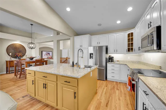 a kitchen with cabinets and chairs