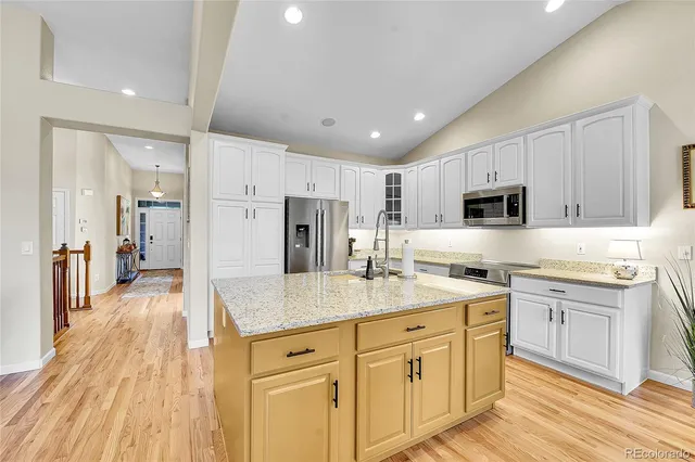 a kitchen with white cabinets sink and stainless steel appliances