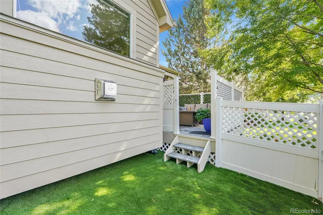 a view of a house with a small yard and wooden fence