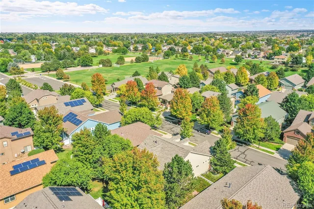 an aerial view of residential houses with outdoor space and trees
